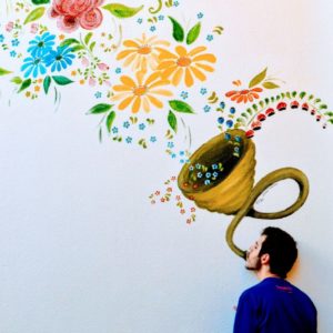 Hombre lanzando mensaje en forma de arreglo floral en pared